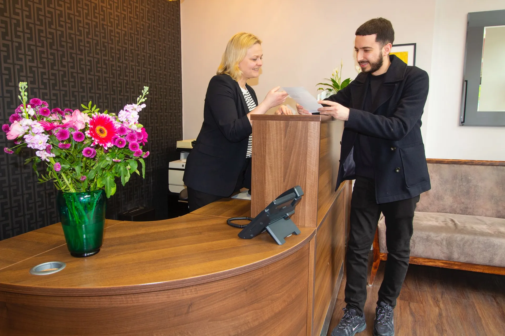 A patient checking in at reception at West London Orthodontist