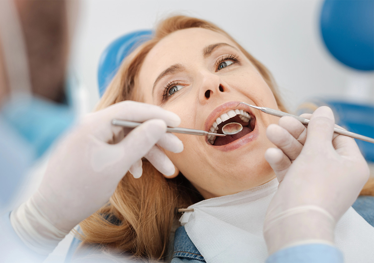 Dental hygienist performing a dental cleaning and oral health checkup in West London