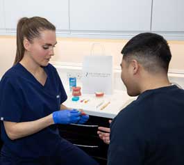 A dental assistant reviewing a patient's teeth during a preventative dental check-up
