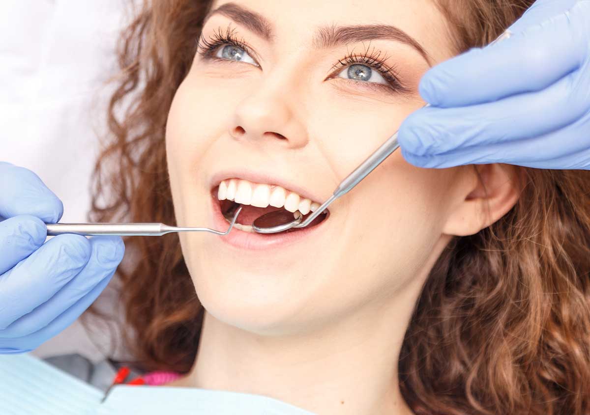 Dentist performing a routine dental checkup and cleaning at West London Orthodontist Cosmetic Dental Studios