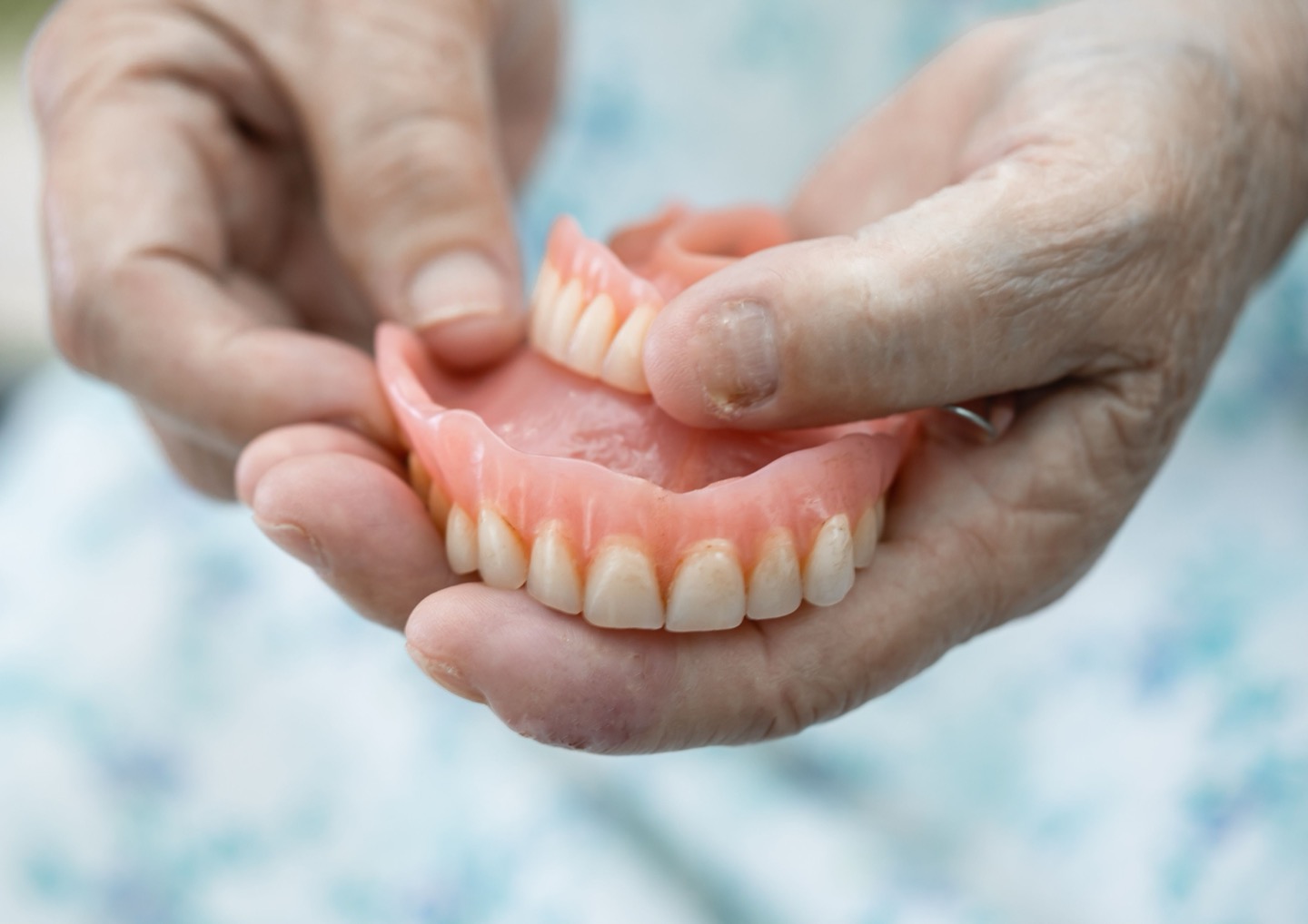 A patient holding a set of full dentures