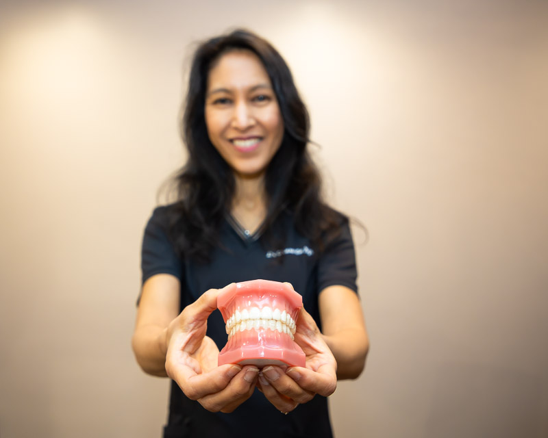Dr Chaw-Su Kyi holding a dental model